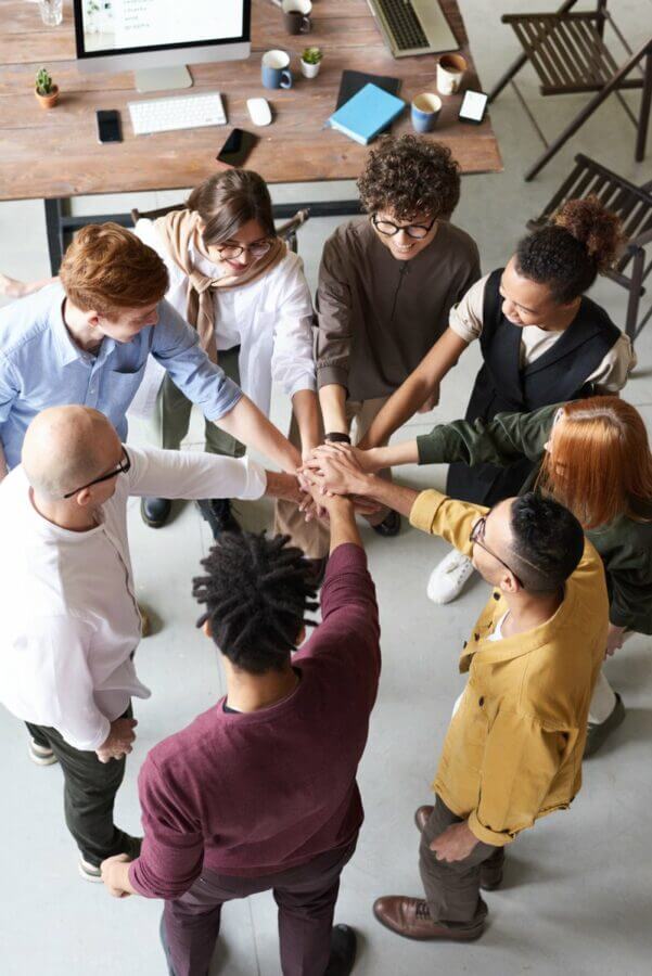 Colleagues in a circle with their hands in the middle on top of one and other