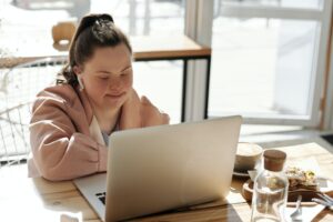 Girl with downs syndrome working on a laptop