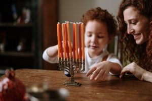 Mother and child look at a Menorah