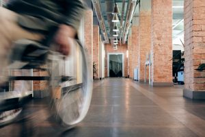 Shot of wheelchair user rolling down hallway