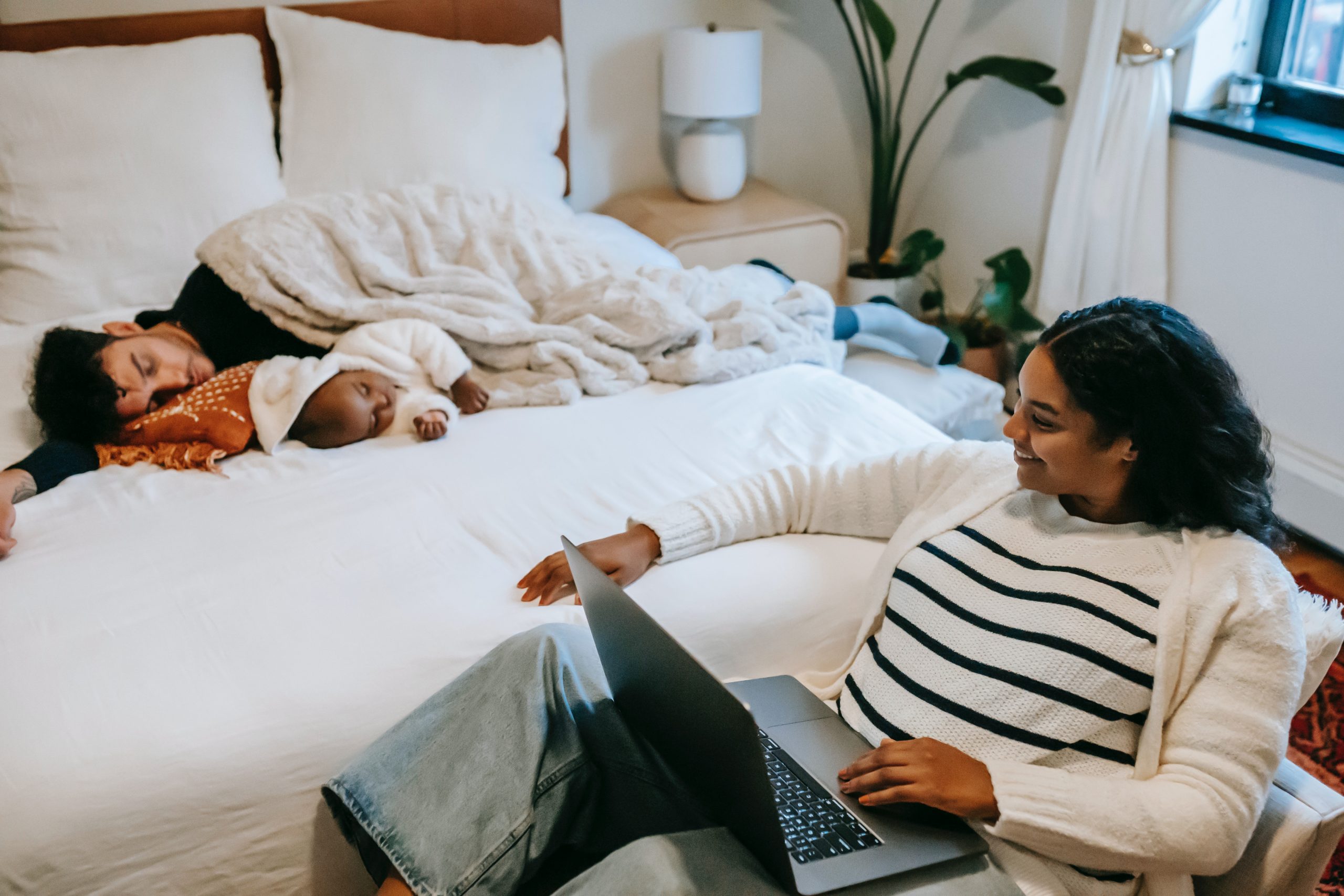 Working mum looking at her husband and child sleeping