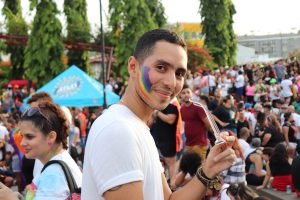 Person looking at the camera with rainbow flag on their cheek