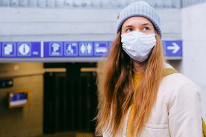 Woman travelling on the underground while wearing a mask