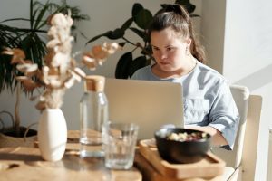 Woman with downs syndrome working on laptop