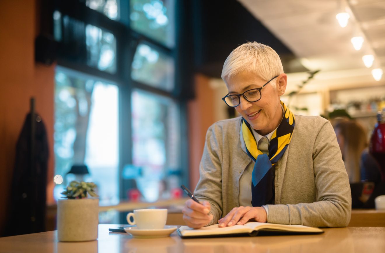 Older woman writing in a notepad