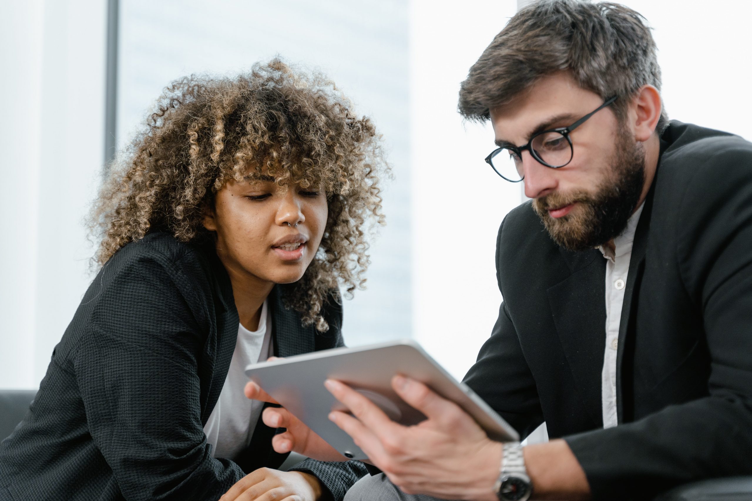 Two people sharing an Ipad to talk about the Inclusive Employers Standard