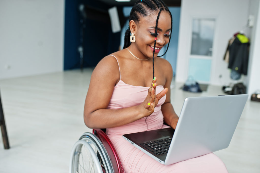 Young disabled black woman in a wheelchair joining a virtual meeting from home