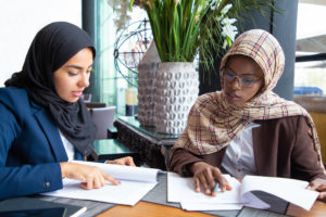 Faith, Religion and belief at work: Two muslim colleagues reading documents for work