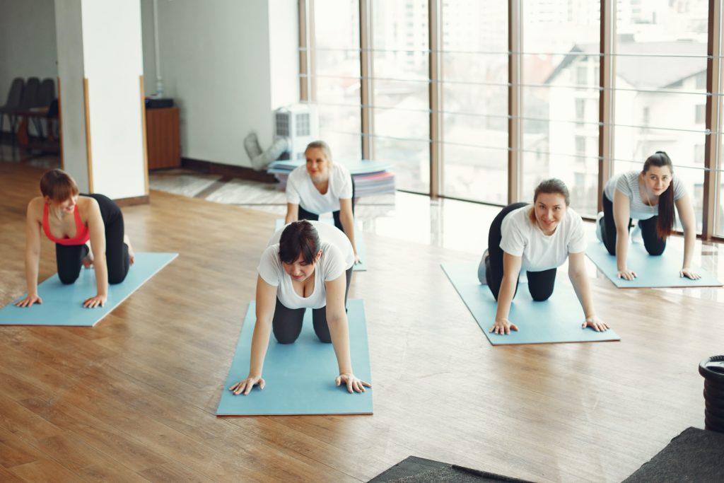 A group of 5 women resting on yoga mats in an exercise class