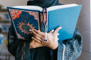 A person holding open an intricately decorated copy of the Quran showing us the cover