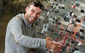 Happy man working on a complicated set of cables and wiring