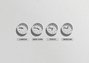 4 white clocks hanging on a white wall with times showing for different countries including: London, New York, Tokyo, Moscow