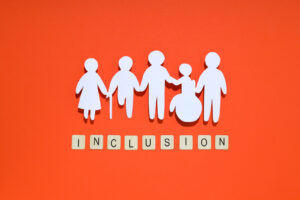 a diverse group of people shaped characters holding hand and the word inclusion written underneath