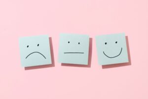 Series of post-it notes with a sad, neutral and happy face.