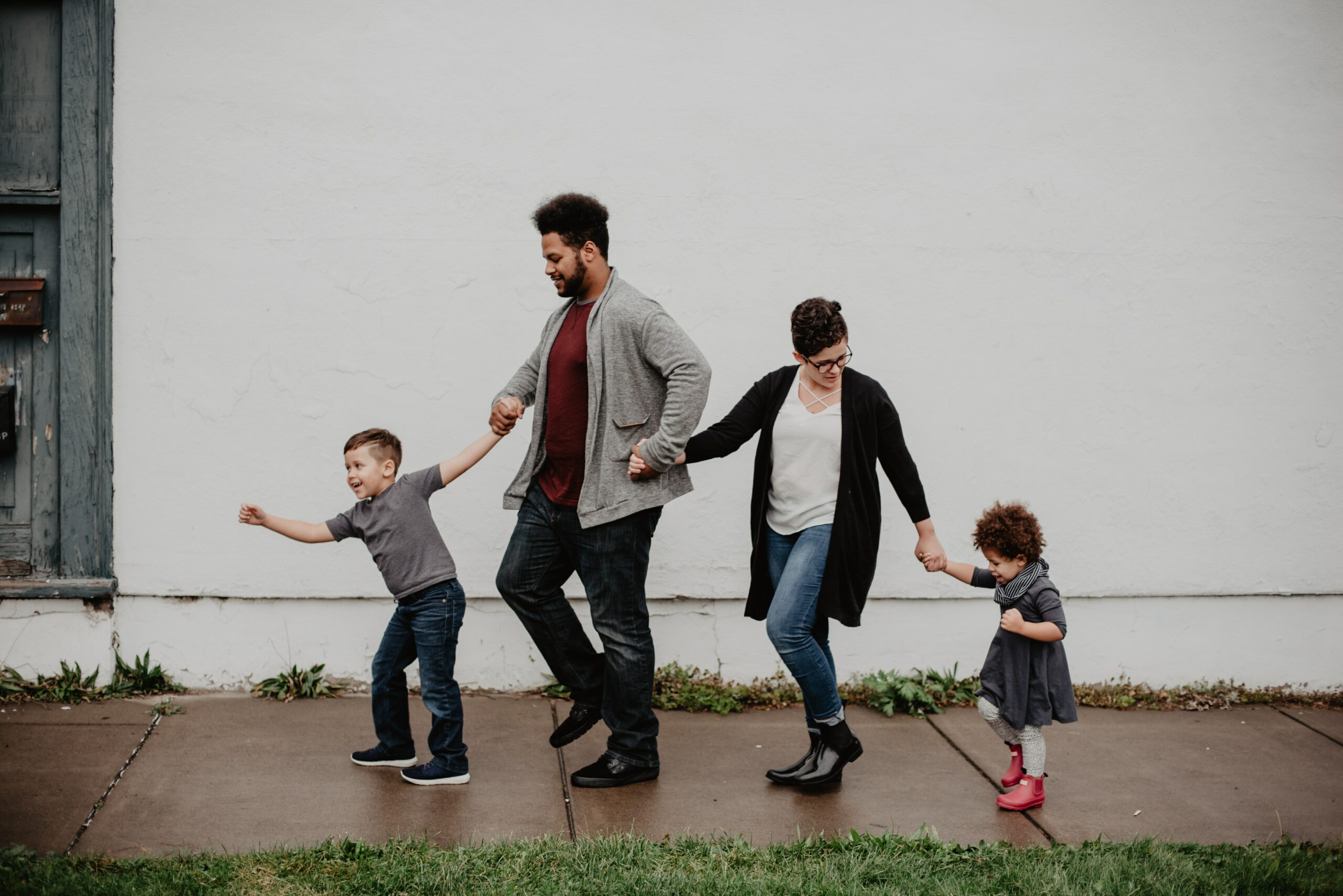 Family walking together in a line while holding hands.
