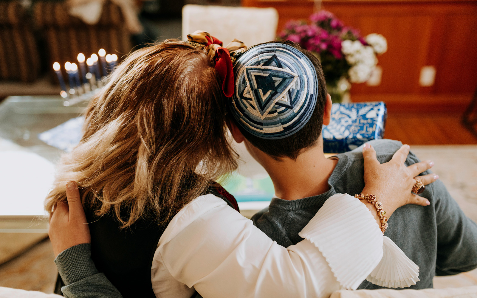 A photo taken from the back of a man and woman's head. The man is wearing a kippah.