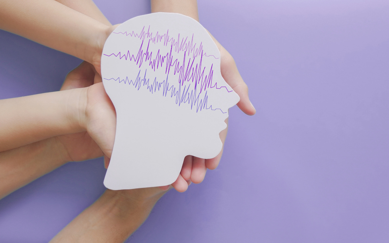 A silhouette of a head showing purple brain waves on a purple background