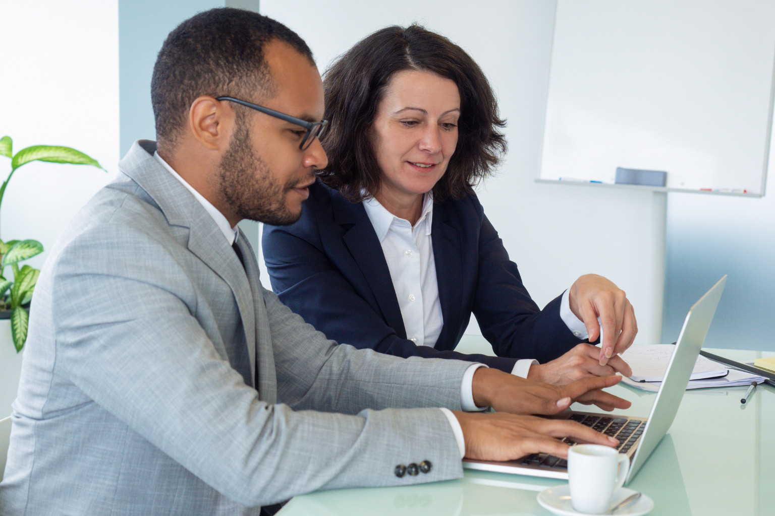 Two office people reviewing their inclusion priorities over a laptop