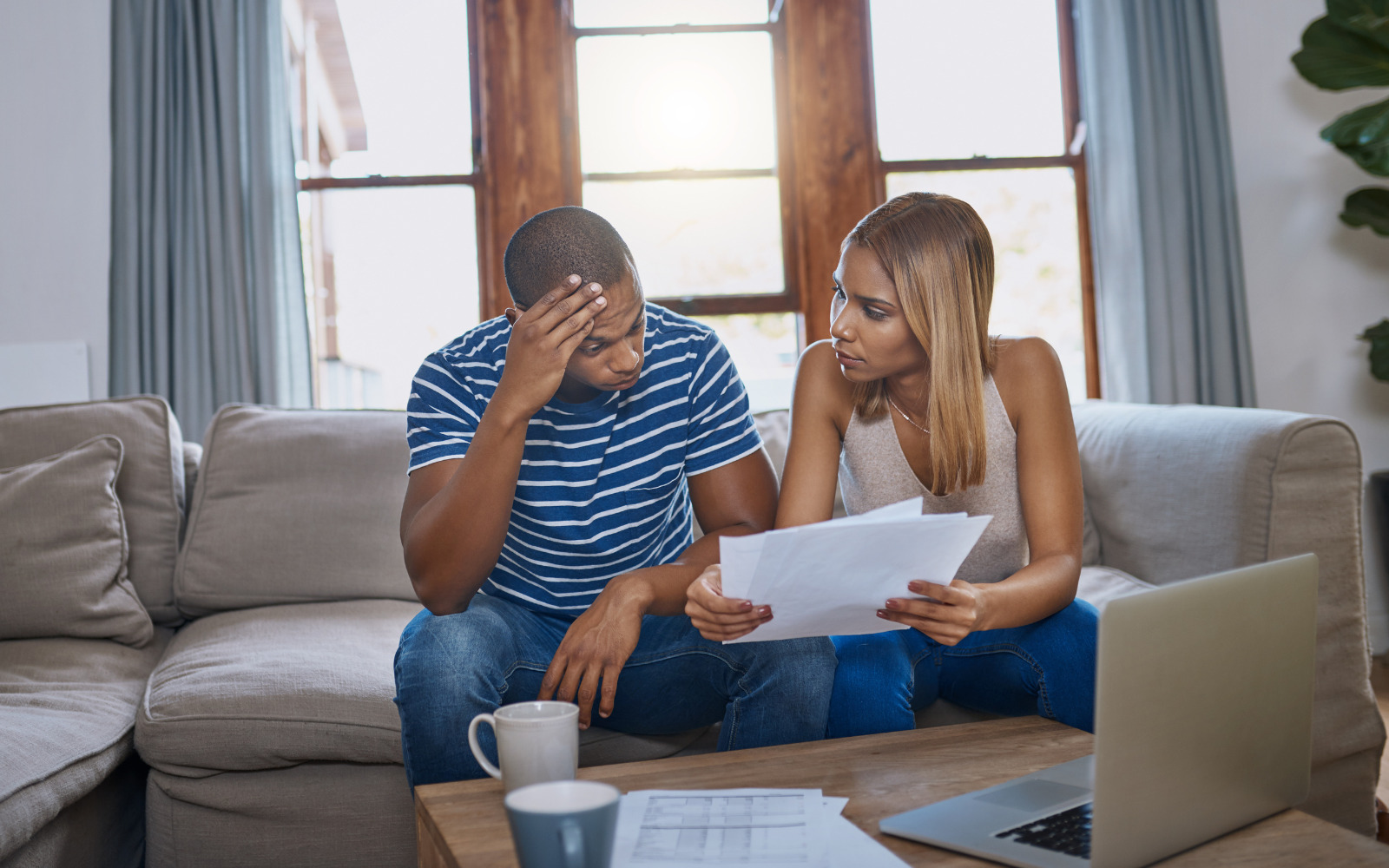 Two people looking stressed while looking at paperwork