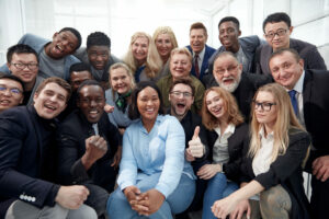 Large diverse group of people smiling and being excited for a photo