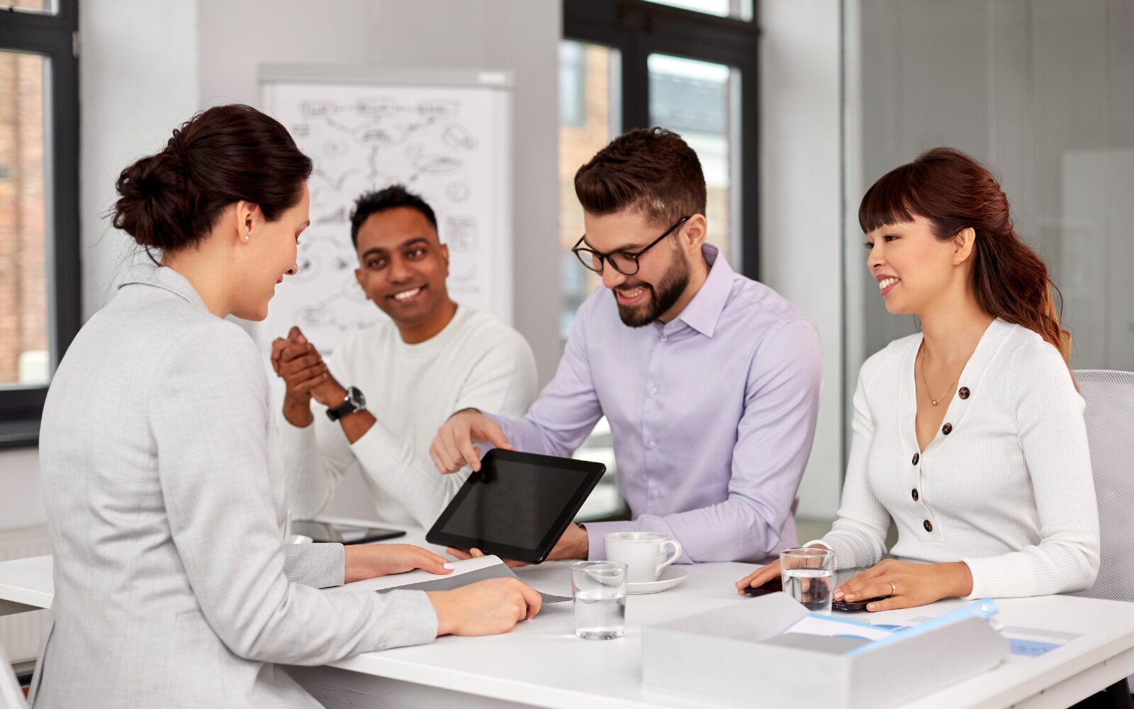 A team of recruiters interviewing a candidate and showing their ideas on a tablet