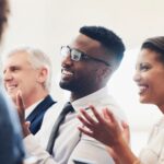 A staff network cheering at a staff network meeting