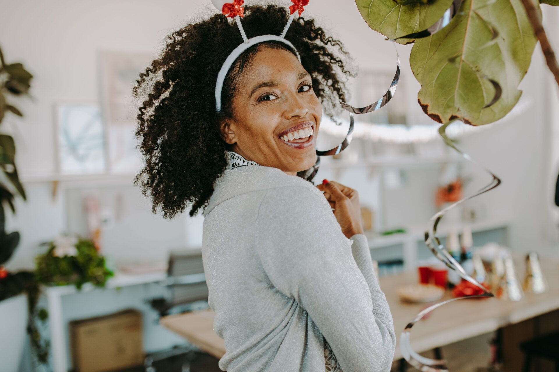 A woman wearing a festive headband smiling and looking at the camera