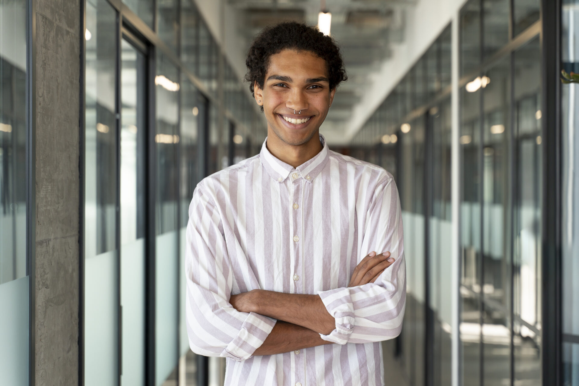 An image of a male-presenting individual look at the camera and smiling